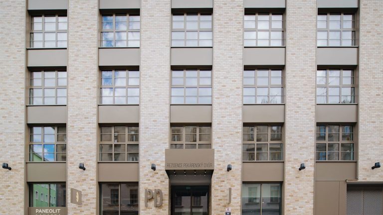 Rezidence Pekárenský dvůr, světlá cihlová fasáda se vstupním portálem