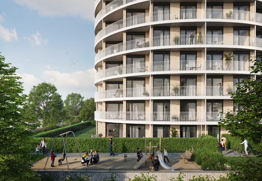 Dětské hřiště na trávníku před zaoblenou fasádou rezidence Zanzara